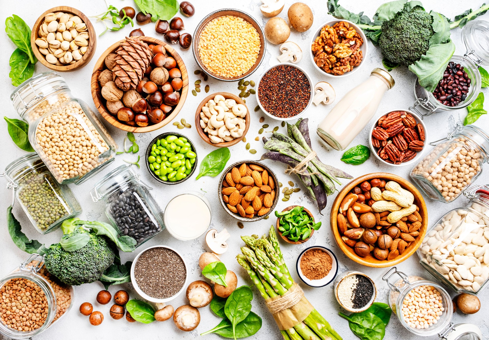 Vegan protein. Full set of plant based vegetarian food sources. Healthy eating, diet ingredients: legumes, beans, lentils, nuts, soy and almond milk, tofu, mushrooms, quinoa, chia, vegetables, spinach, seeds and sprouts. Top view